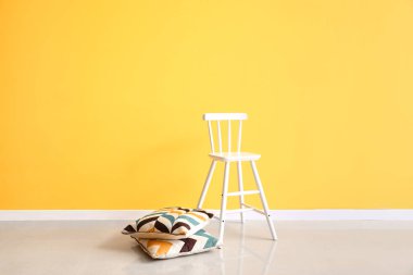 Renkli duvarın yanında modern sandalye ve yastıklar