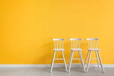 Sarı duvarın yanındaki modern sandalyeler