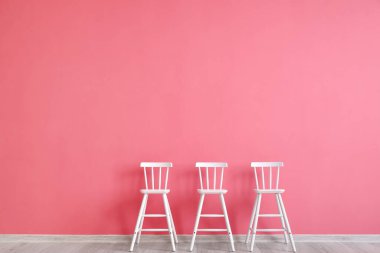 Pembe duvarın yanındaki modern sandalyeler