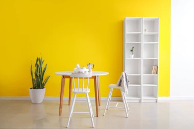 Yemek masası ve raf ünitesi olan modern odanın içinde.