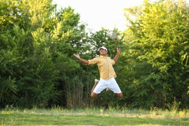 Dışarıda badminton oynayan genç bir Afro-Amerikalı.