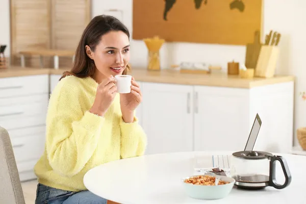 Morgen Smuk Kvinde Med Laptop Drikker Kaffe Derhjemme - Stock-foto