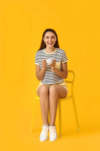 Mooie Vrouw Met Kopje Koffie Zitten Stoel Tegen Kleur Achtergrond — Stockfoto