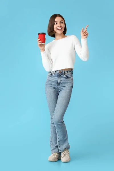 Mooie Vrouw Met Kopje Koffie Wijzend Naar Iets Kleur Achtergrond — Stockfoto