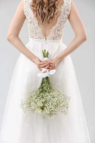 Açık arkaplanda çiçek demeti olan güzel gelin.