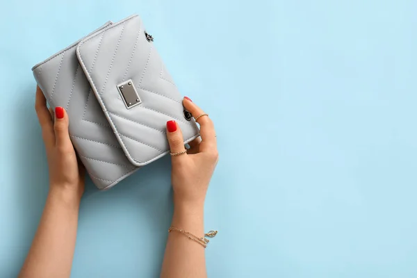 Junge Frau Mit Stylischem Schmuck Hält Handtasche Auf Farbigem Hintergrund — Stockfoto
