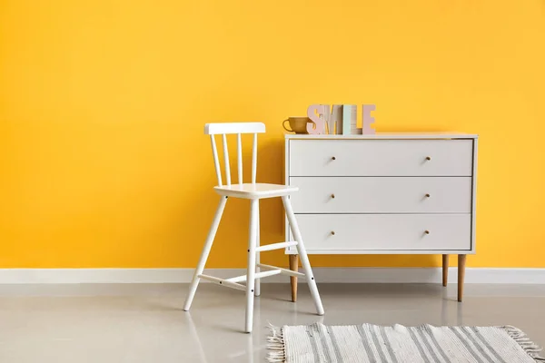 Μοντέρνα Καρέκλα Και Συρταριέρα Κοντά Χρωματιστό Τοίχο — Φωτογραφία Αρχείου