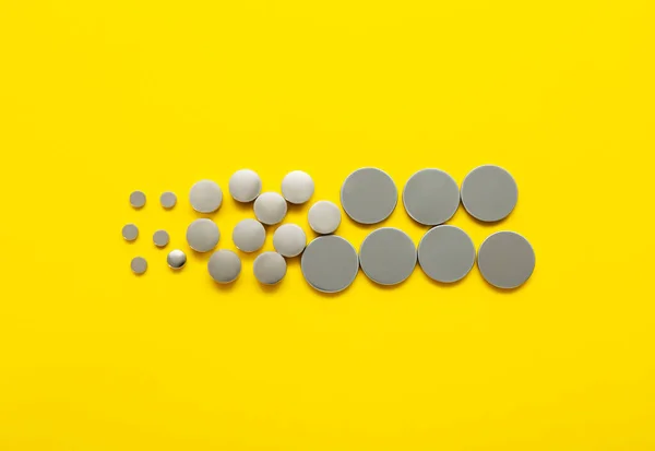 黄色の背景にリチウムボタン電池 — ストック写真