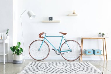 Bisikleti ve masası olan aydınlık oturma odasının içinde.