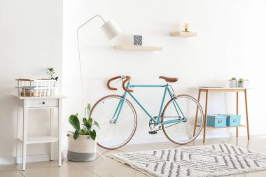 Interior of light living room with bicycle and table clipart