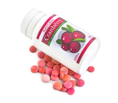 Beyaz arka planda bir şişe kızılcık hapı.