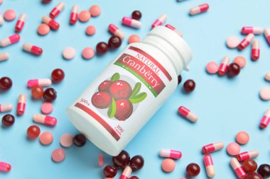 Bir şişe yabanmersini hapı ve renkli böğürtlen.