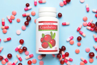 Bir şişe yabanmersini hapı ve renkli böğürtlen.