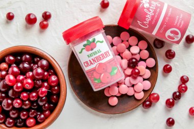 Kızılcık haplı şişeler ve arka planda böğürtlenler, yakın plan.