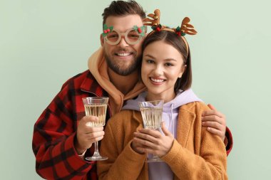 Yılbaşı dekoru ve arka planda şampanya bardakları olan genç bir çift.