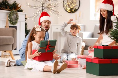 Sevimli küçük kız evde Noel hediyesi kutusu açıyor.