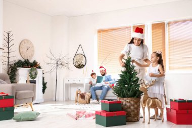 Anne ve küçük kızı Noel arifesinde evde köknar ağacı süslüyorlar.