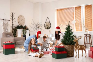 Noel 'i evde kutlayan hediyeli mutlu aile.