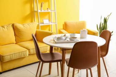 Masalı, parlak sarı yemek odasının içi.