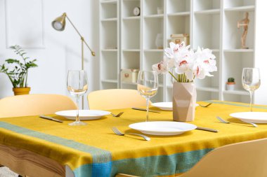 Modern odadaki servis masasında çiçekli vazo.