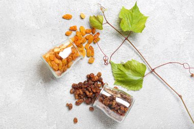 Hafif arka planda farklı tatlı üzümlü cam kavanozlar.