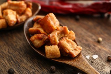 Ahşap arka planda lezzetli çıtırtıları olan kaşık.