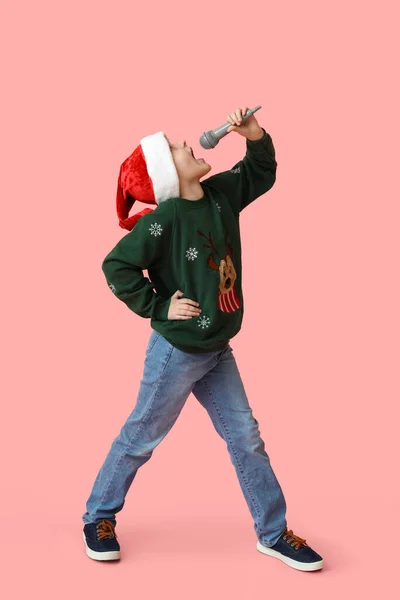 Kleiner Junge Mit Weihnachtsmütze Und Mikrofon Singt Weihnachtslied Auf Farbigem — Stockfoto