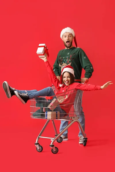 Joyeux Jeune Couple Avec Panier Cadeaux Noël Sur Fond Couleur — Photo