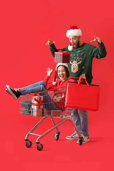 Joyeux Jeune Couple Avec Panier Cadeaux Noël Sur Fond Couleur — Photo