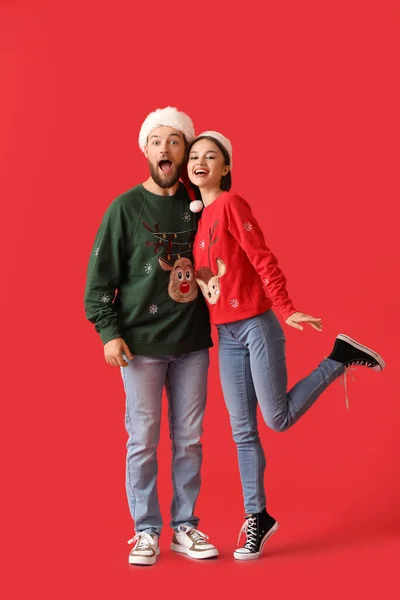 Ευτυχισμένο Νεαρό Ζευγάρι Κομψά Χριστουγεννιάτικα Ρούχα Στο Φόντο Χρώμα — Φωτογραφία Αρχείου