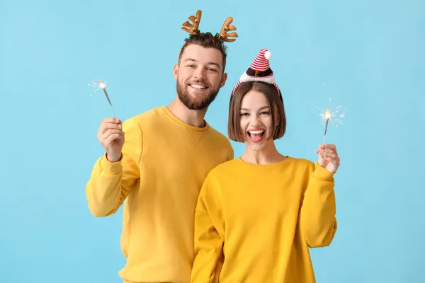 Glückliches Junges Paar Stilvoller Winterkleidung Und Mit Wunderkerzen Auf Farbigem — Stockfoto