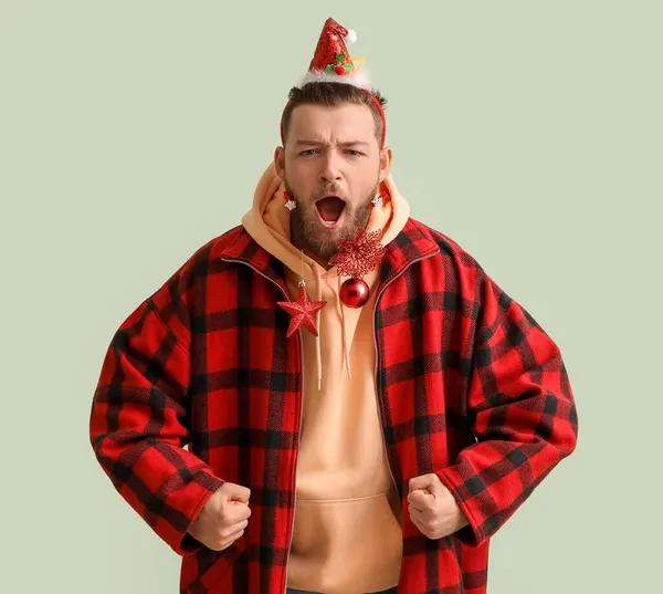 Křičící Mladý Muž Stylovém Zimním Oblečení Vánoční Výzdobou Světlém Pozadí — Stock fotografie