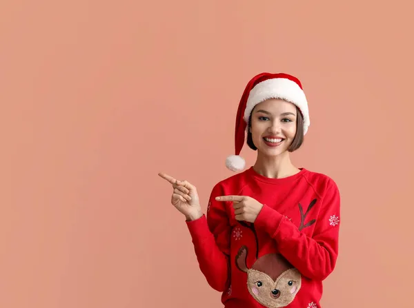 Young Woman Stylish Christmas Clothes Santa Claus Hat Showing Something — Stock Photo, Image
