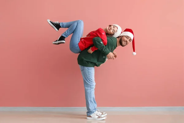Счастливая Молодая Пара Стильной Рождественской Одежде Веселится Цветном Фоне — стоковое фото