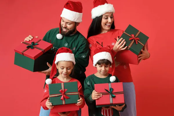 Happy Family Santa Hats Christmas Gifts Red Background — Stock Photo, Image