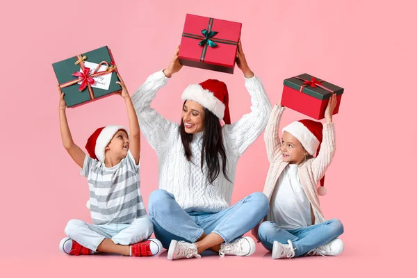Junge Mutter Mit Ihren Kleinen Kindern Und Weihnachtsgeschenken Auf Rosa — Stockfoto