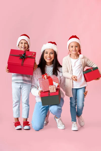 Jovem Mãe Com Seus Filhos Pequenos Presentes Natal Fundo Rosa — Fotografia de Stock