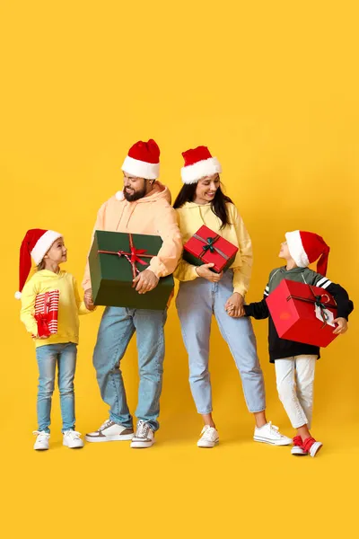 Ευτυχισμένη Οικογένεια Σάντα Καπέλα Δώρα Χριστουγέννων Κίτρινο Φόντο — Φωτογραφία Αρχείου