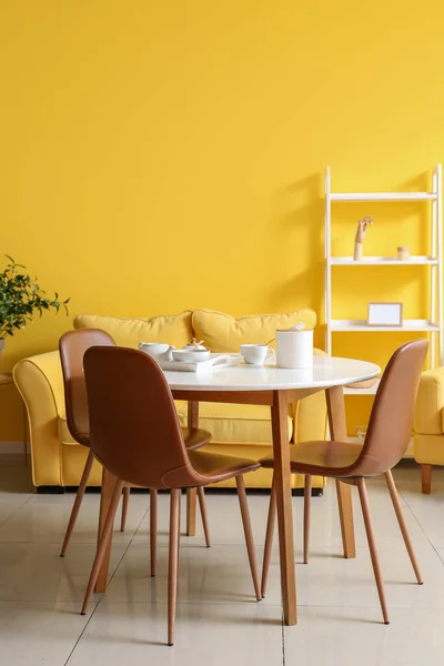 Interior of bright yellow dining room with table