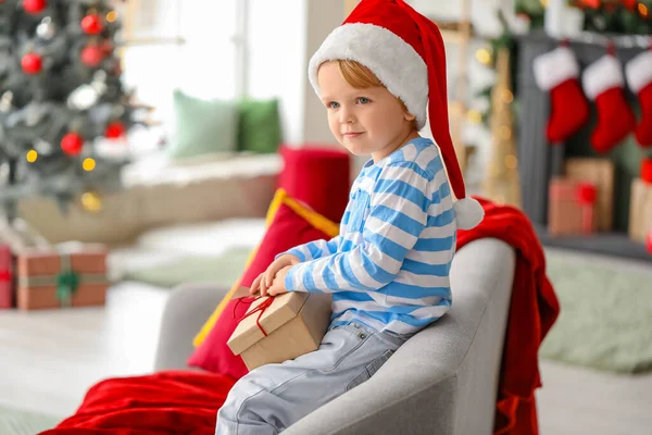 サンタの帽子の小さな男の子とクリスマスの前夜に家での贈り物 — ストック写真