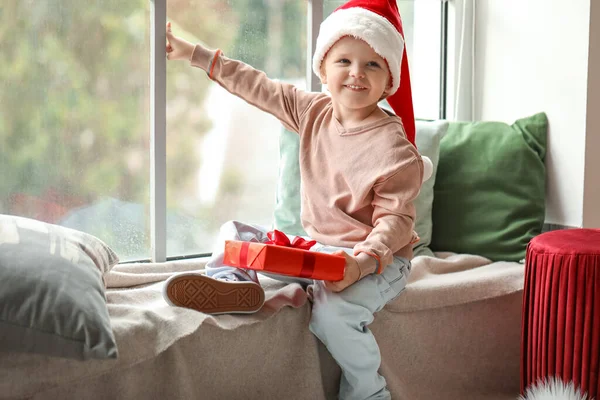 Kleiner Junge Mit Weihnachtsmütze Und Weihnachtsgeschenk Fenster — Stockfoto