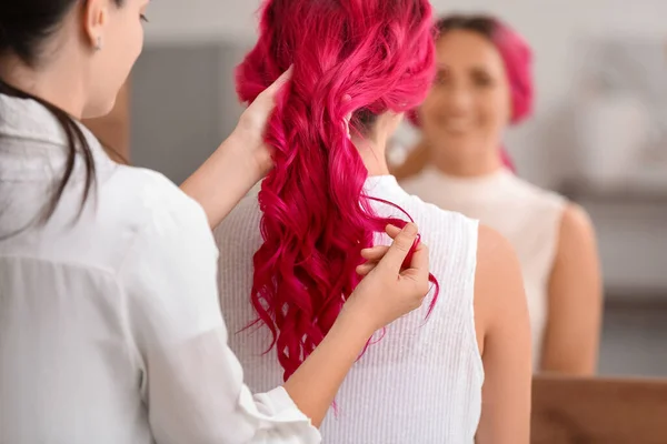 在美容院为年轻女子做头发的造型师 — 图库照片