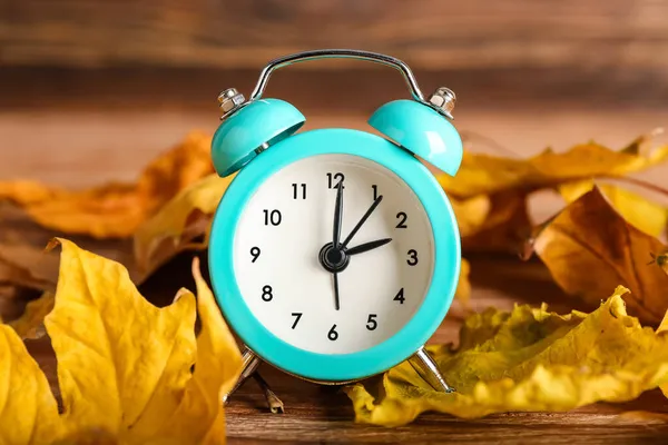 Alarm Hodiny Podzimní Listí Dřevěném Pozadí Konec Letního Času — Stock fotografie