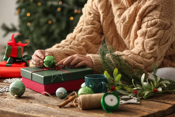 テーブルの屋内でクリスマスギフトボックスを飾る女性 クローズアップ — ストック写真