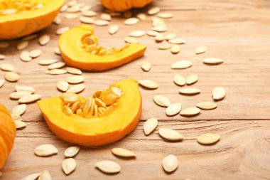 Doğal kabak tohumları ve ahşap arka planda taze sebzeler.