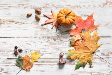 Sonbahar yapraklı kompozisyon, balkabağı ve fındık hafif ahşap arka planda