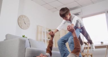 Adam ve küçük oğlu evde oynuyorlar.