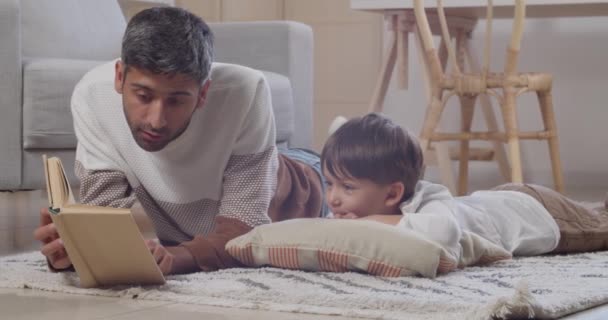 Mann Liest Seinem Kleinen Sohn Hause Buch Vor — Stockvideo