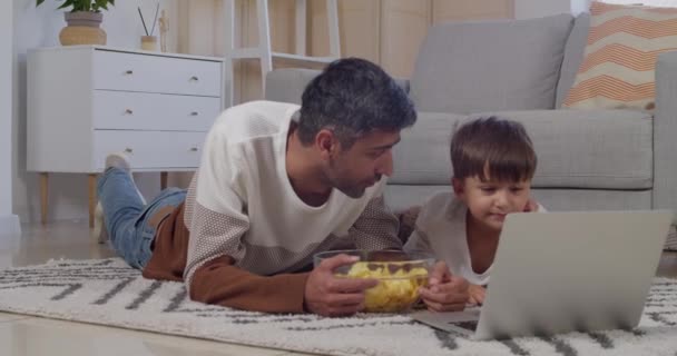 Homem Seu Filho Com Laptop Comendo Chips Casa — Vídeo de Stock