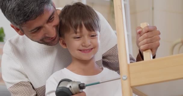 Hombre Pequeño Hijo Ensamblando Muebles Casa — Vídeos de Stock